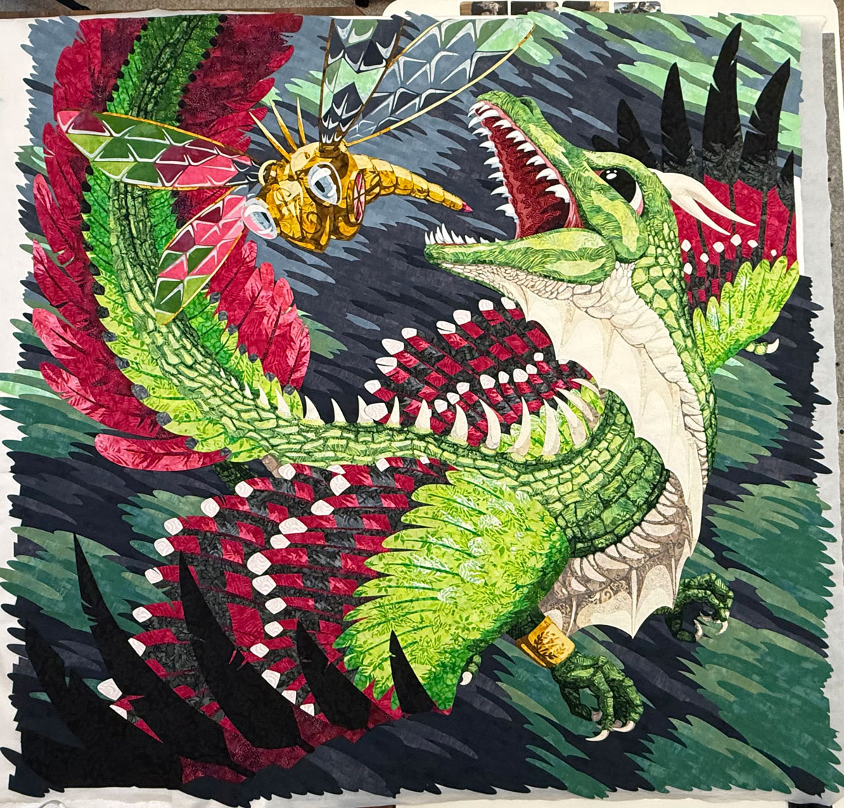 High Stakes, a quilt of a dragon with feathered wings chasing a mechanical dragonfly